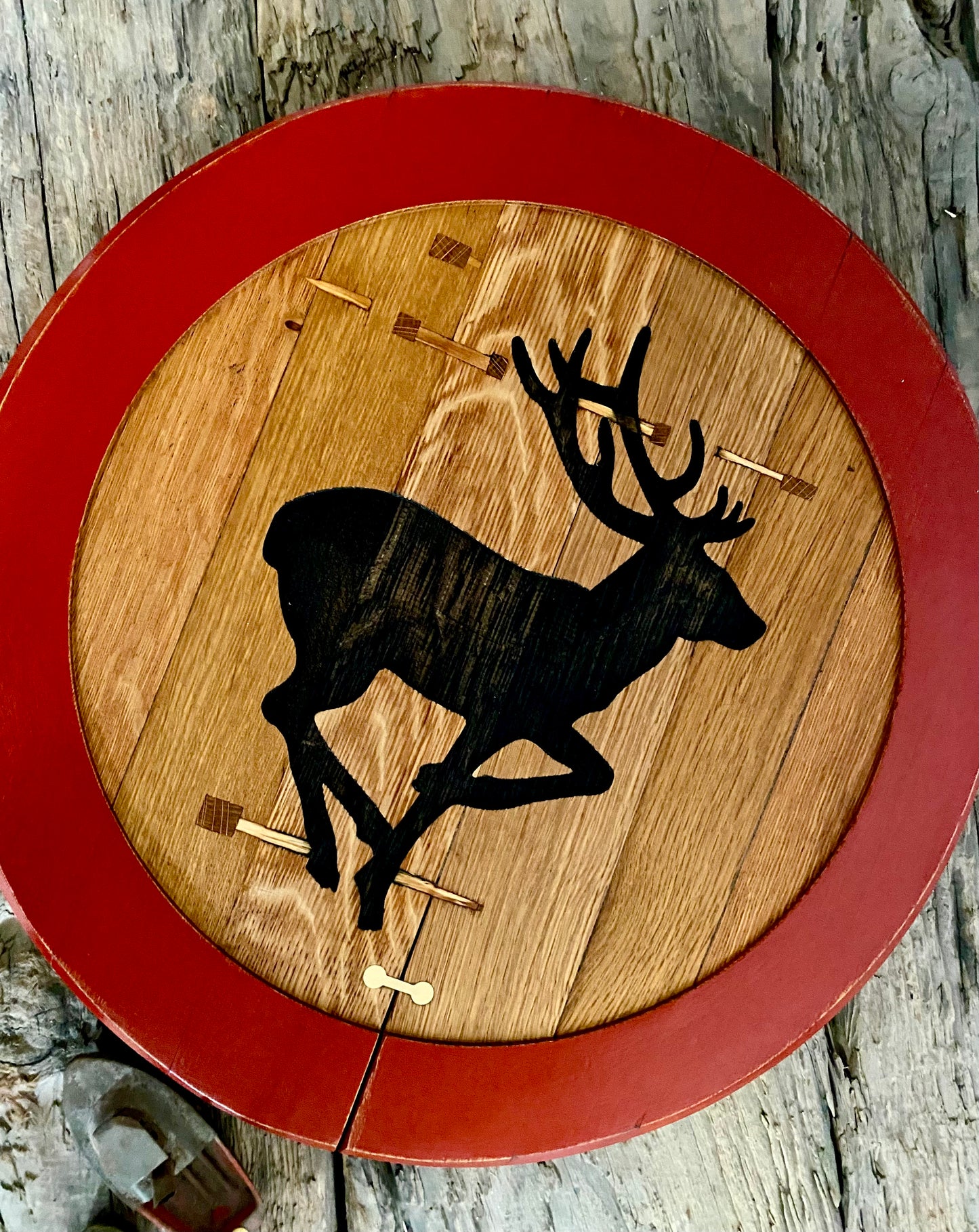 Handcrafted rustic oak wall art featuring a stag silhouette, made from reclaimed Scottish whisky barrel wood with brass bowtie joints and eco-friendly red painted border – inspired by Scottish road signs.