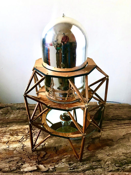 An striking mid-century structural table lamp with  a domed mirror and reclaimed oak frameword- perfect for bold interiors that celebrate the harmony of design and sustainability.
This exceptional piece combines reclaimed oak, brass accents, a vintage mirror, and a striking dome repurposed from a mid-century vacuum thermos.