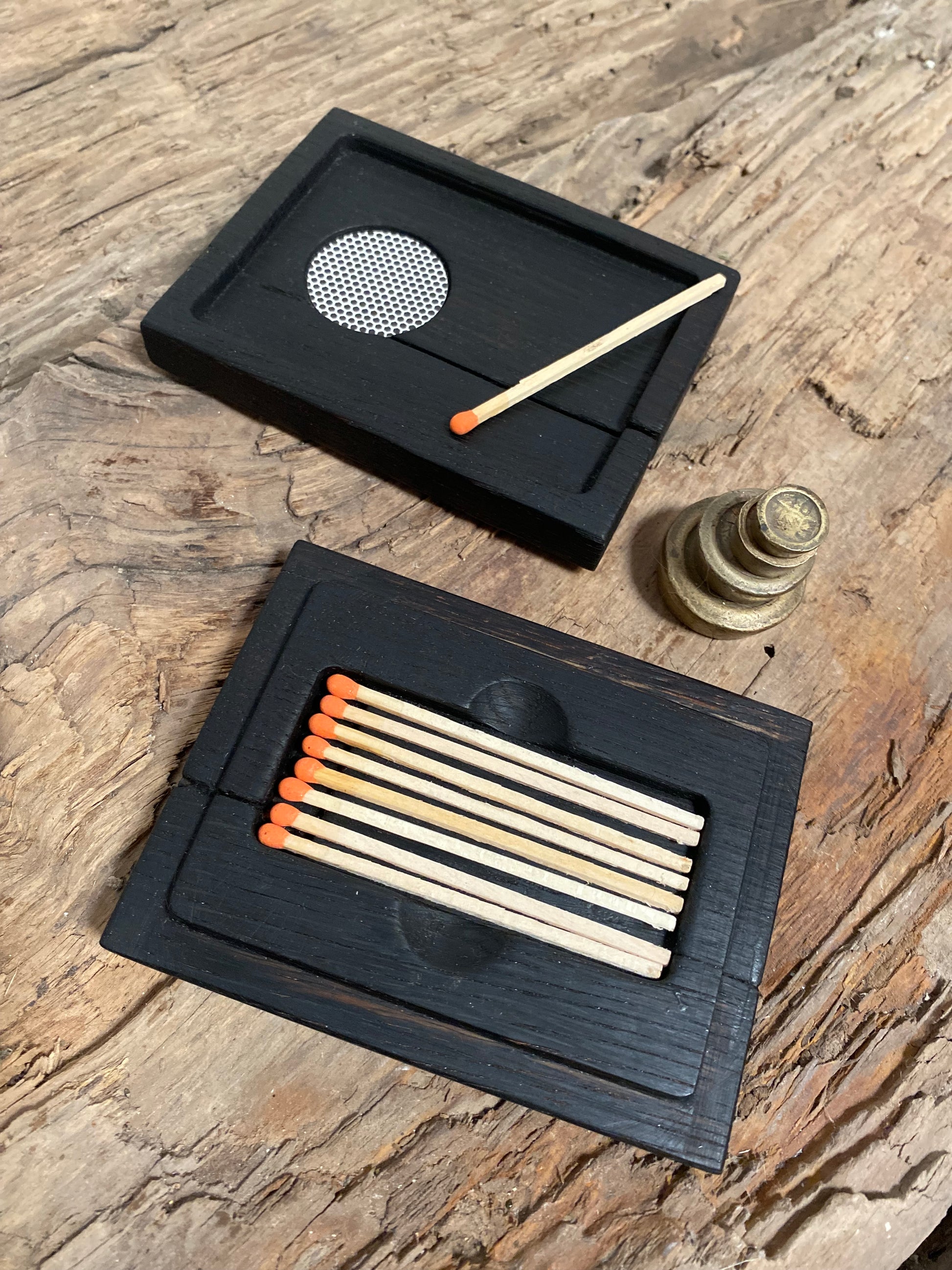 Rustic reclaimed oak matchbox chest featuring a bold burnt surface finish. Holds tall color-tipped matches with a striking lid for easy use. Handcrafted with sustainable materials and unique bowtie joints—perfect for candles, firesides, or as a thoughtful gift