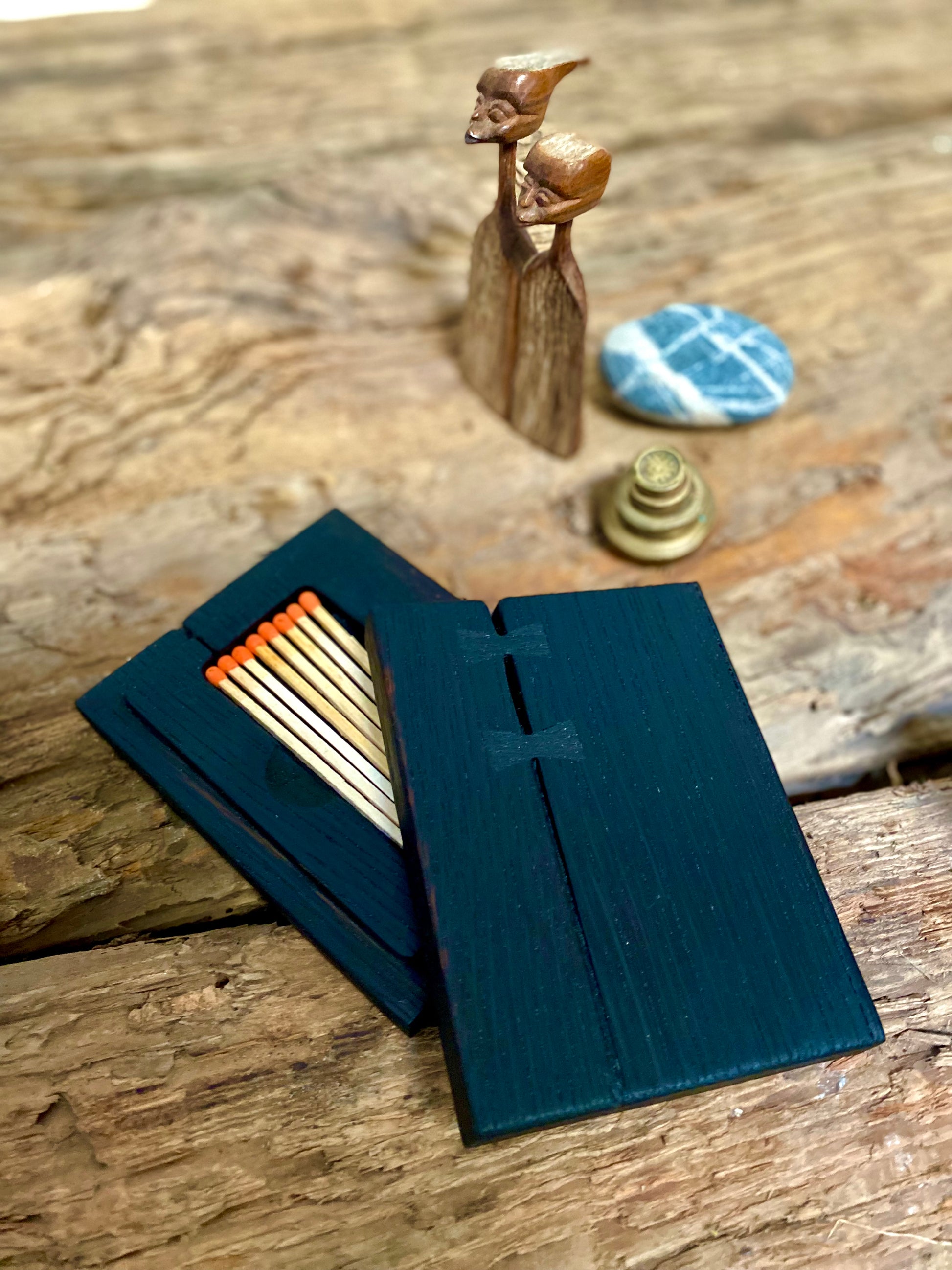 Rustic reclaimed oak matchbox chest featuring a burnt surface finish. Holds tall color-tipped matches with a striking lid for easy use. Handcrafted with sustainable materials and bowtie joints—perfect for candles, firesides, or as a thoughtful gift