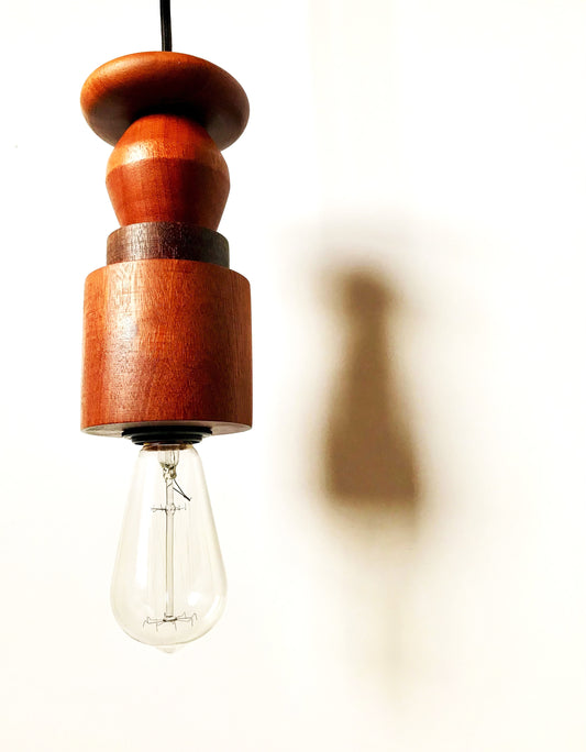 Rustic pendant light consisting of hardwood geometric beads threaded onto a lighting fitting.