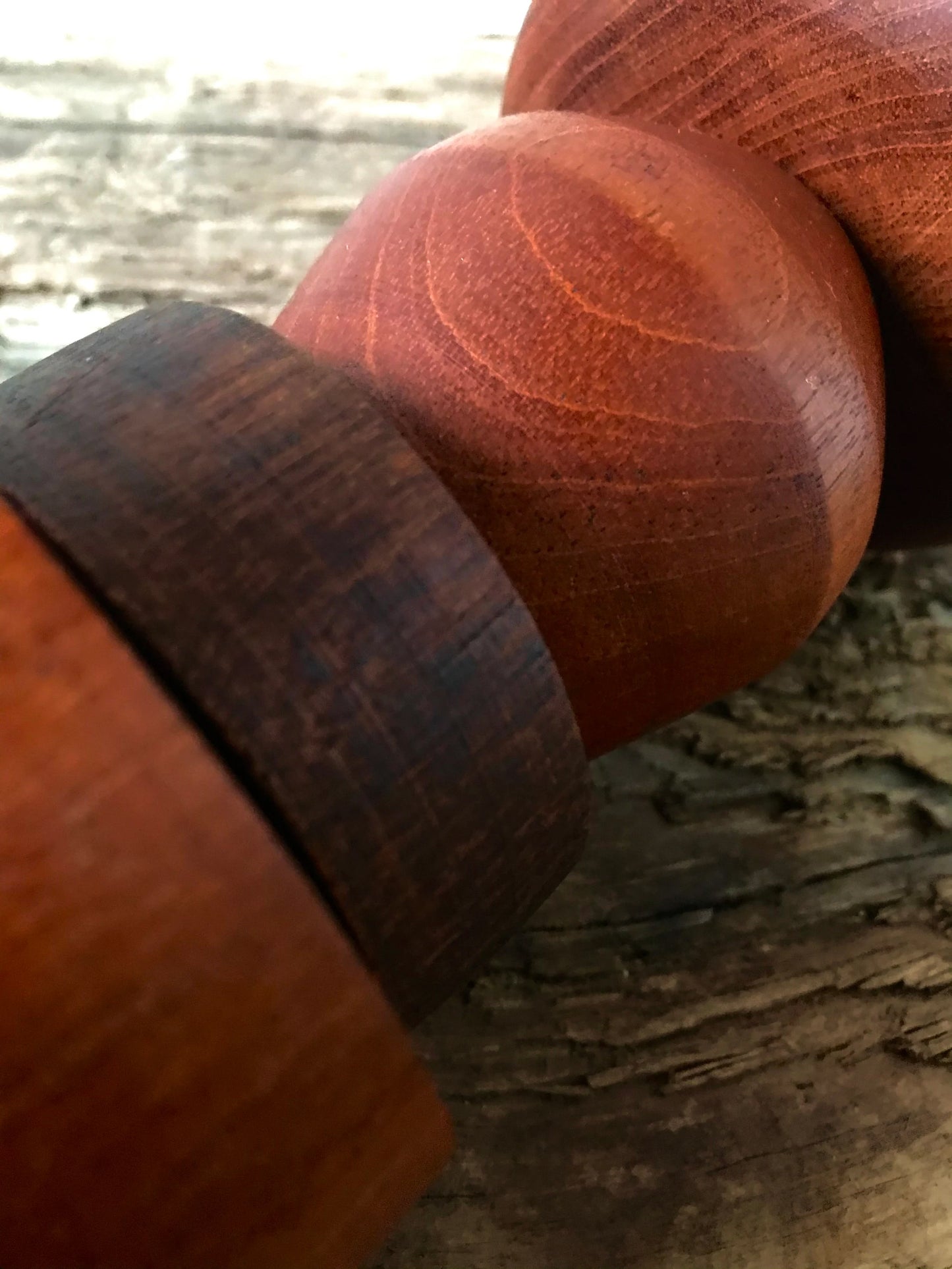 Detail of a rustic pendant light consisting of large hardwood geometric beads threaded onto a lighting fitting.