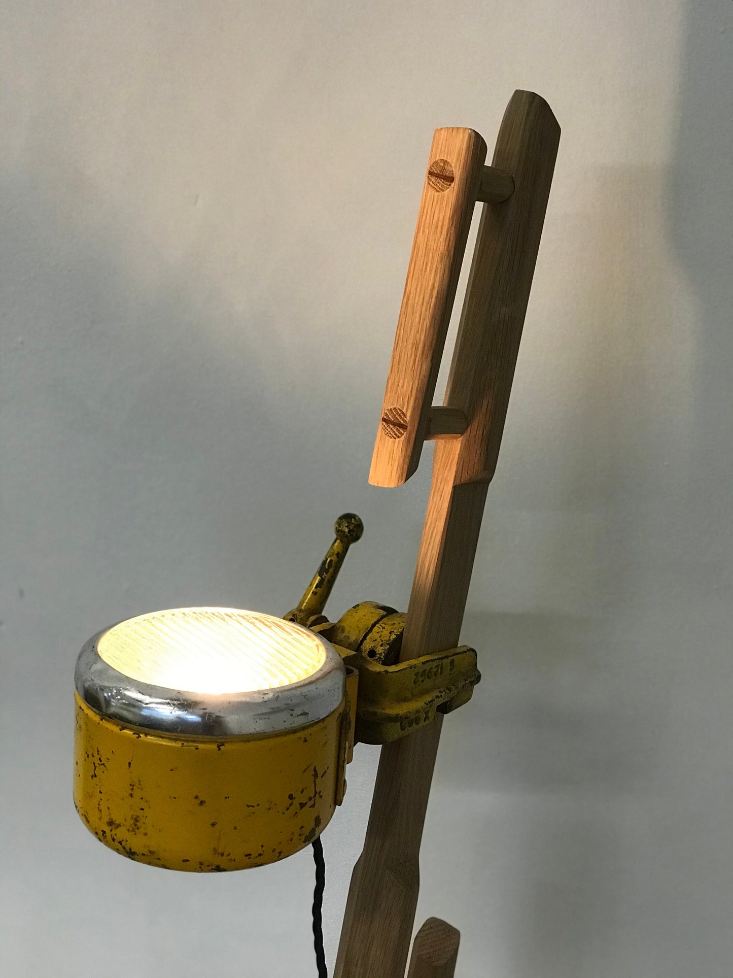 Upcycled floor light crafted from a rustic oak and a vintage yellow spotlight