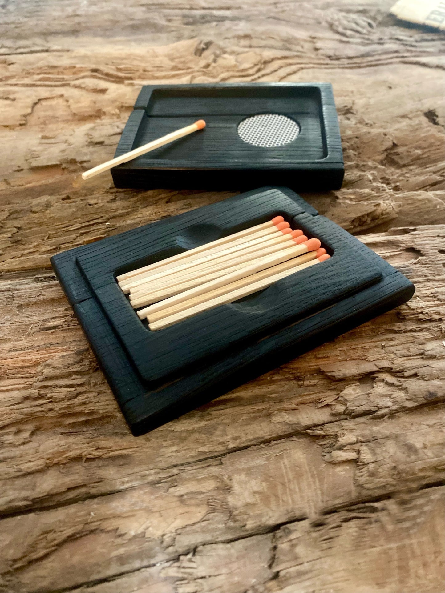 Handcrafted reclaimed oak chest with striking charred surface texture, perfect as a matchbox for fireside ambiance or rustic decor. Sustainable design with color-tipped matches, bowtie joinery, and a convenient strike lid—functional and stylish for home rituals.