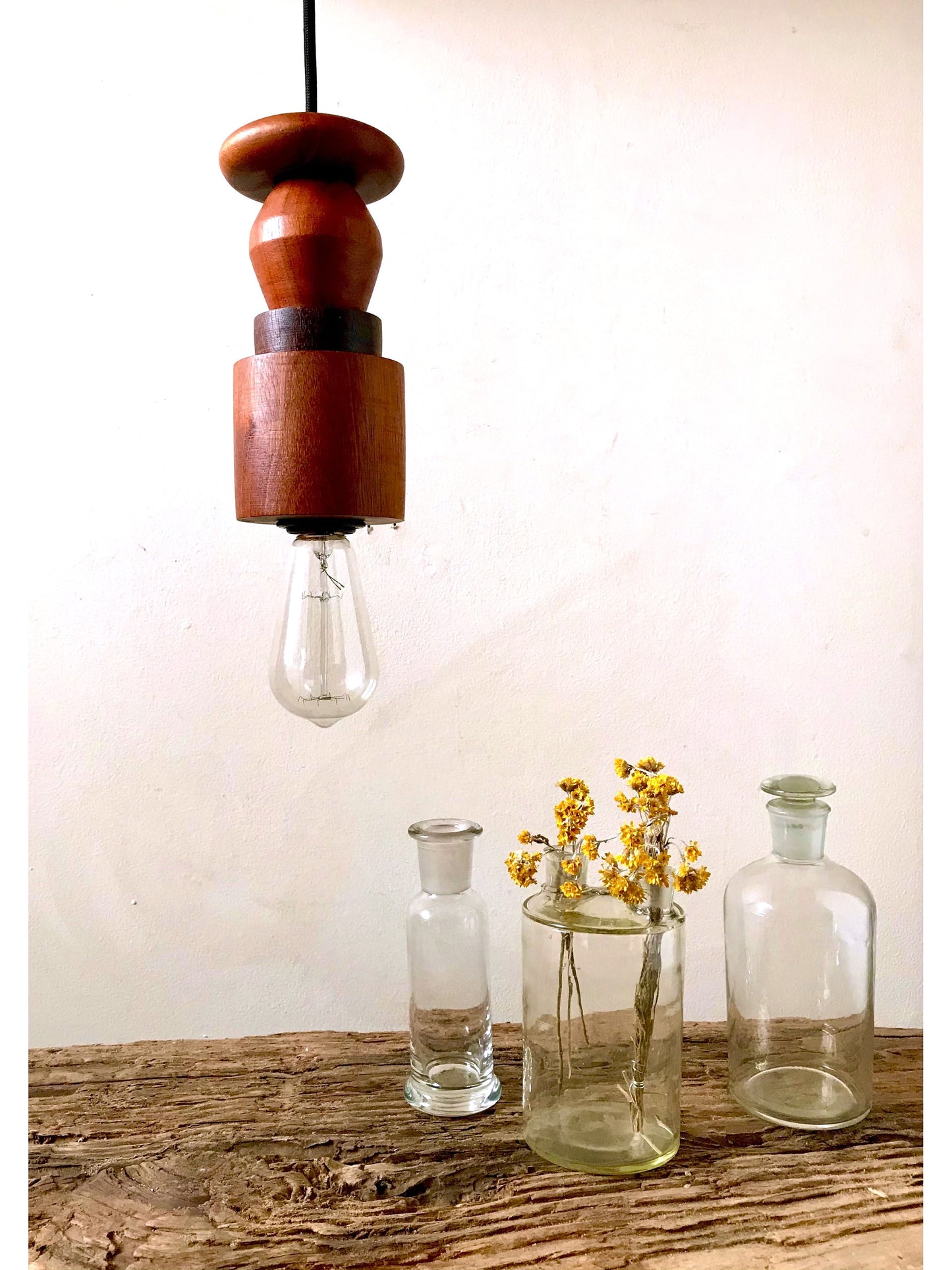 Rustic pendant light consisting of hardwood geometric beads threaded onto a lighting fitting.