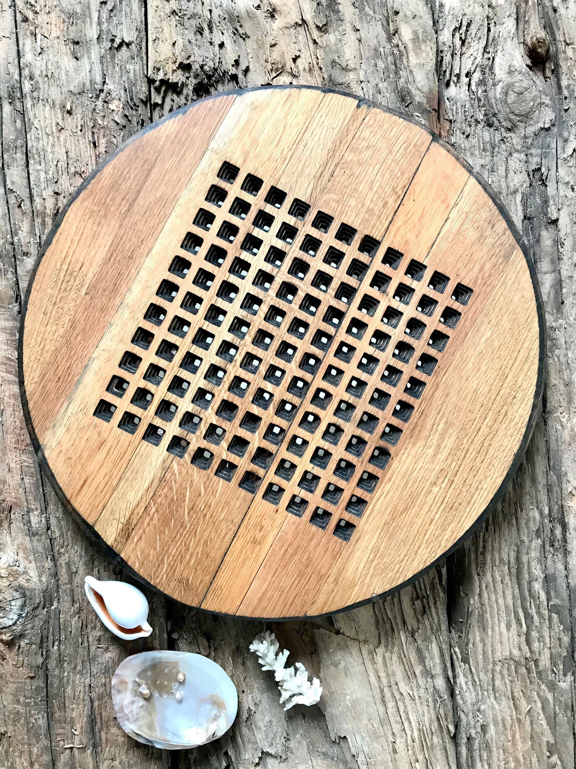 A round mirror with a 10 x 10 square pattern precisely etched on to the surface of a piece of reclaimed circular oak