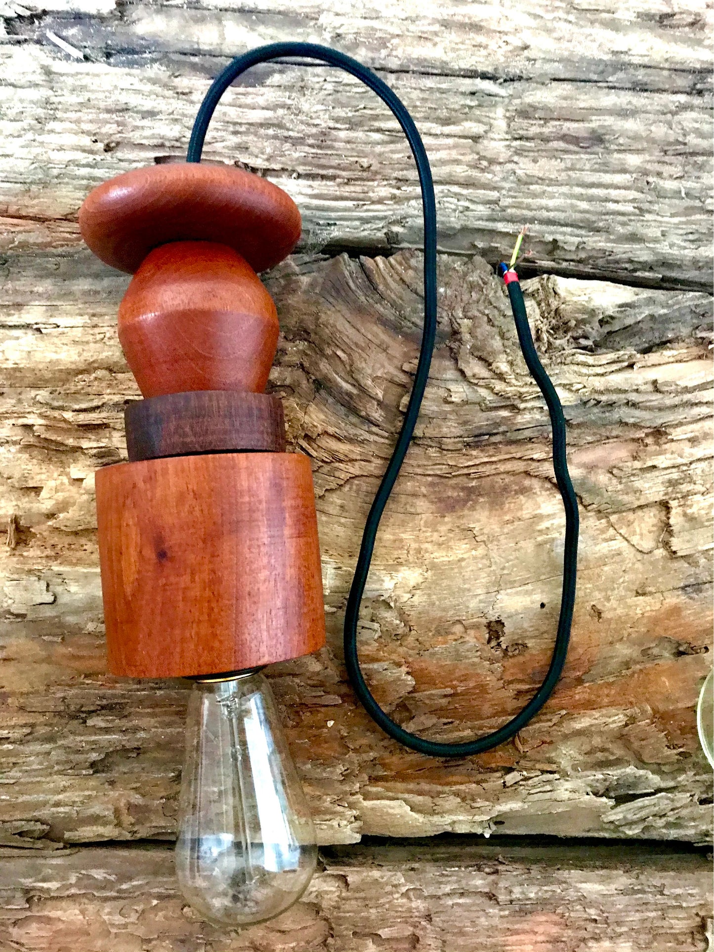 Rustic pendant light consisting of hardwood geometric beads threaded onto a lighting fitting.