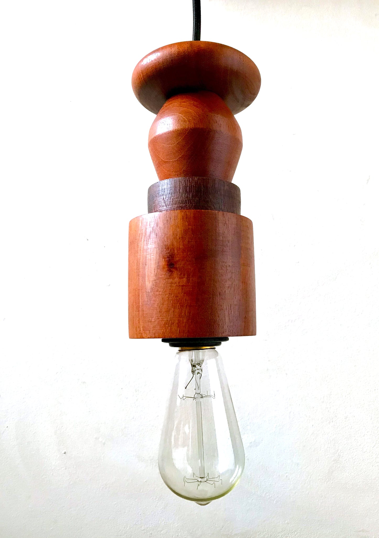 Rustic pendant light consisting of hardwood geometric beads threaded onto a lighting fitting.