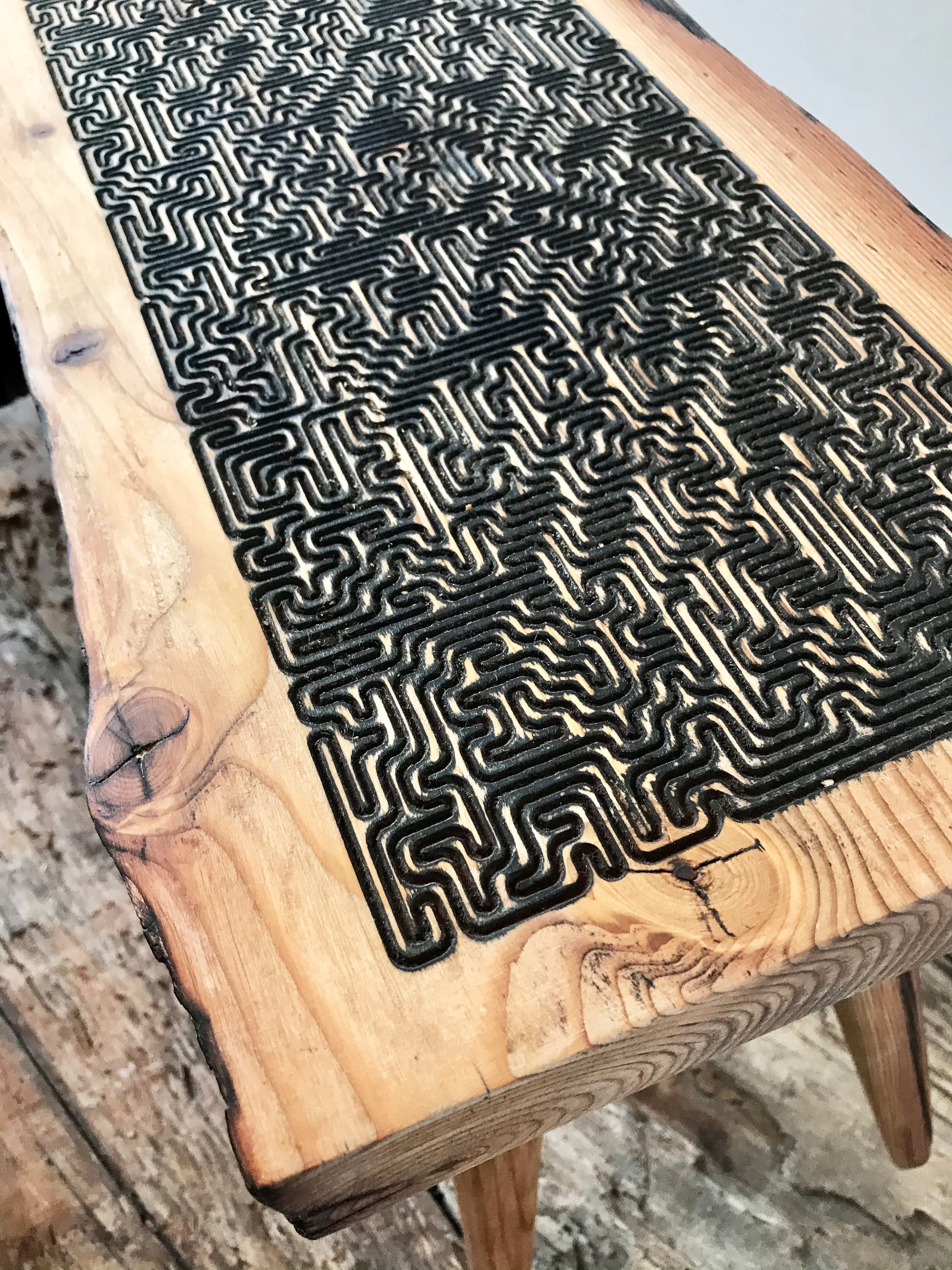 Tabletop with maze pattern, etched using a maze algorithm, inviting moments of reflection and mindfulness. 